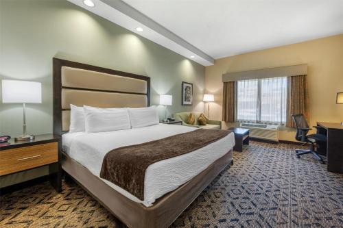 a hotel room with a large bed and a desk at Best Western Plus College Park Hotel in College Park