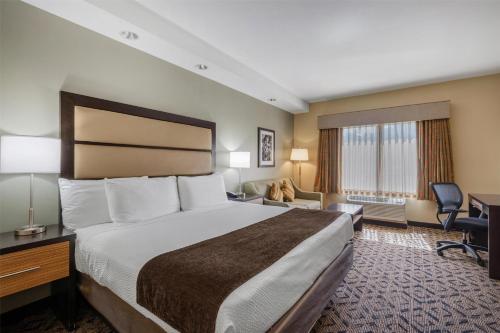 a hotel room with a bed and a desk at Best Western Plus College Park Hotel in College Park