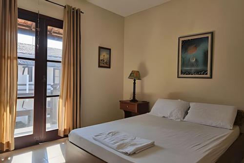 a bedroom with a bed and a large window at Acesso a Praia com Área Gourmet in Saquarema