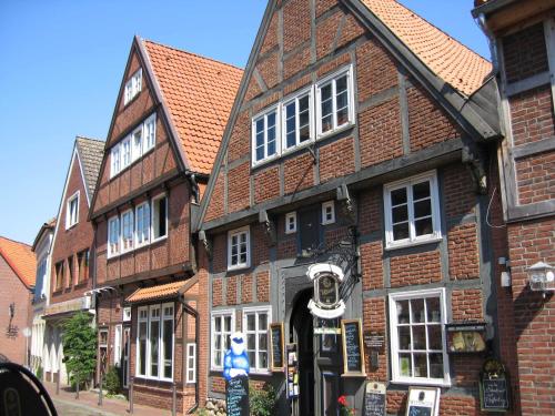 a large brick building with white windows on a street at Ferienhaus Deichgraf 65 im Feriend in Hollern-Twielenfleth
