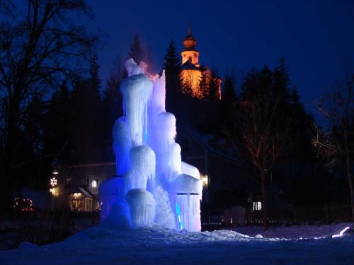 an ice castle at night with a building in the background at Pircherhof - Urlaub und Erholung im Troadkost'n in Sankt Kathrein am Hauenstein