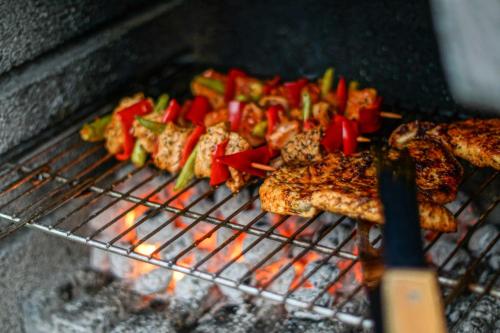 a grill with meat and vegetables on it at Haff-Ostseeferienhaus Nebengebäude in Mönkebude