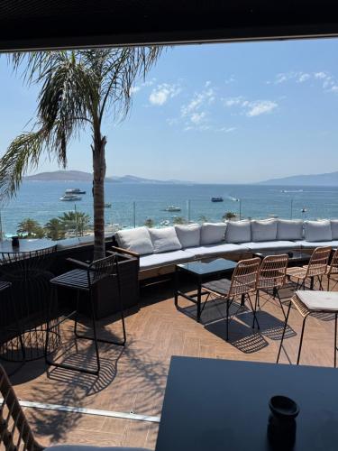 a patio with a couch and chairs and the ocean at Diamond Central Boutique Hotel in Sarandë