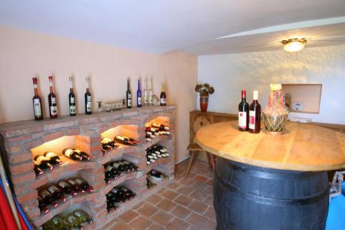a room with a brick fireplace with wine bottles at Kellerstöckl Leitner in Strem