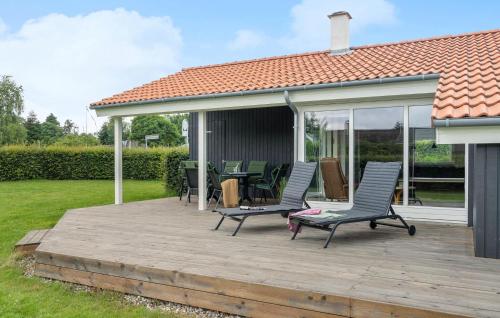 a deck with chairs and tables on a house at Beautiful Home In Børkop With Sauna in Børkop