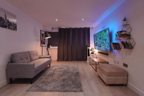 a living room with a couch and a tv at Smart Apartment close to Watford Atria and Station in Watford