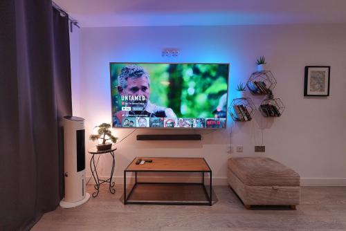 a living room with a flat screen tv on the wall at Smart Apartment close to Watford Atria and Station in Watford