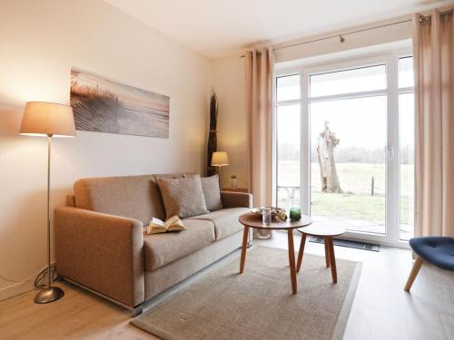un salon avec un canapé et une table dans l'établissement Residenz Haffblick, Wohnung 37, à Boltenhagen