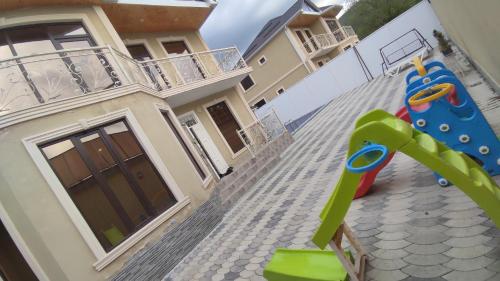 a house with a playground in front of a house at Twin villas VSL in Gabala