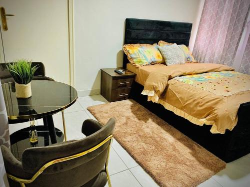 a bedroom with a bed and a glass table at Danimax Villa in Accra