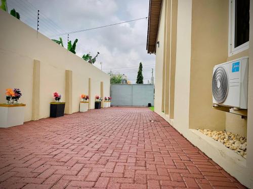 an empty hallway of a building with a brick sidewalk at Danimax Villa in Accra