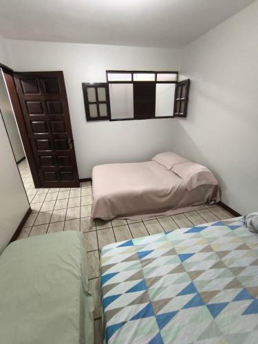 una camera con due letti e una porta di Hostel São Geraldo a Garanhuns