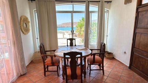 a dining room with a table and chairs and a large window at Casa Mar, Near Balandra Beach in Pichilnque
