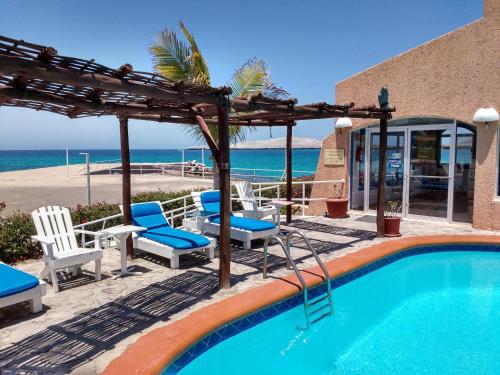 a swimming pool with chairs and a view of the beach at Casa Mar, Near Balandra Beach in Pichilnque