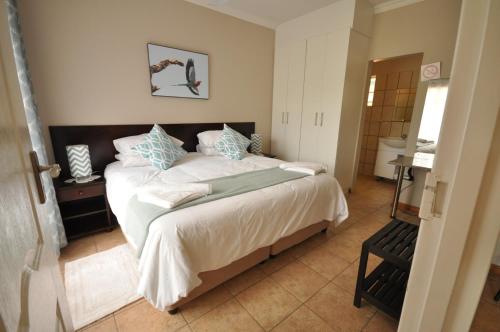 a bedroom with a large white bed with blue pillows at Eden Cottage in White River