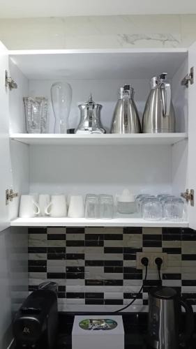 a kitchen shelf with dishes and glasses on it at Appartement Etoilé in Tetouan