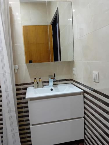 a bathroom with a white sink and a mirror at Appartement Etoilé in Tetouan