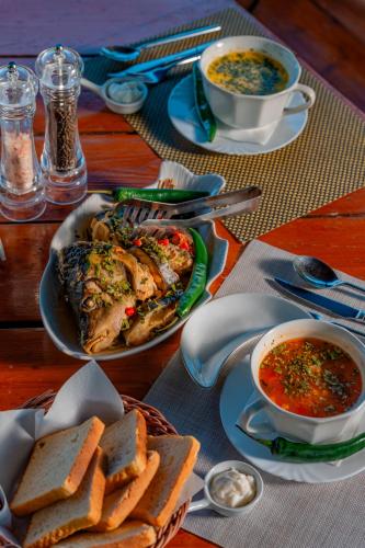 a table with a plate of food and a bowl of soup at Pensiunea Ovidiu in Crisan