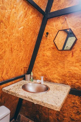 a bathroom with a sink and a light on a wall at Tepuy Hostel in Boa Vista