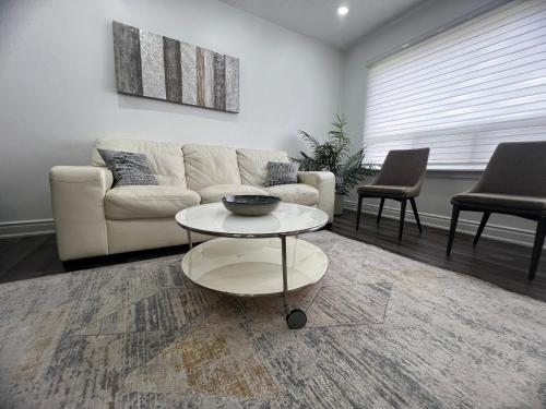 a living room with a couch and a table at Three Bedroom Spacious Bangalow with Free Parking, closer to commercial area and highways in Mississauga