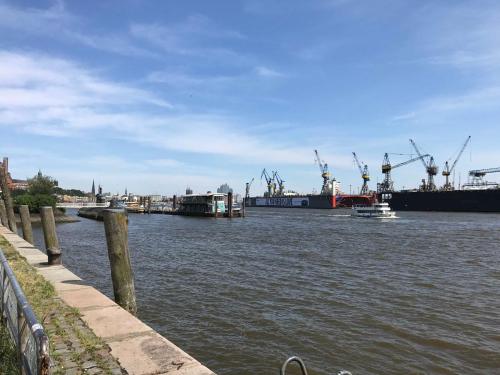 a river with two ships and a boat in the water at Ferienhaus Robinson im Feriendorf Altes Land direkt an der Elbe in Hollern-Twielenfleth