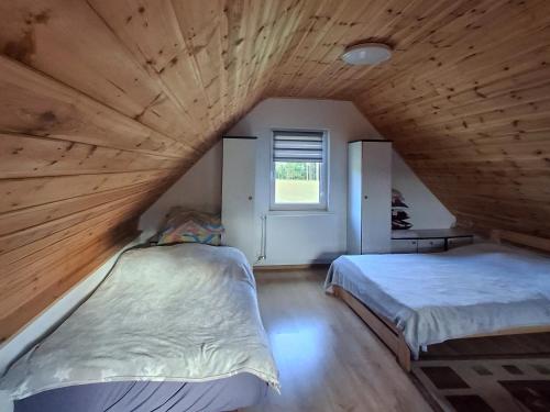 a room with two beds and a window at Domek wypoczynkowy-całoroczny in Skórcz