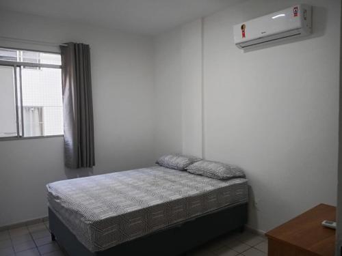 een kleine slaapkamer met een bed en een raam bij Apt amplo 3 quartos Manaíra in João Pessoa