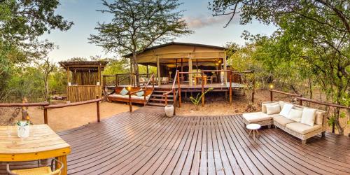 a wooden deck with a gazebo and a couch at Ngama Tented Safari Lodge in Guernsey Nature Reserve