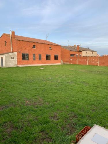 a building with a field of grass in front of it at Casa cómoda, amplia y tranquila 