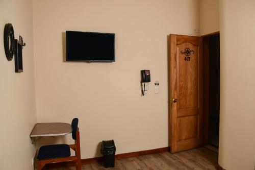 a room with a door and a television on the wall at Hotel Villa Colonia in Marinilla