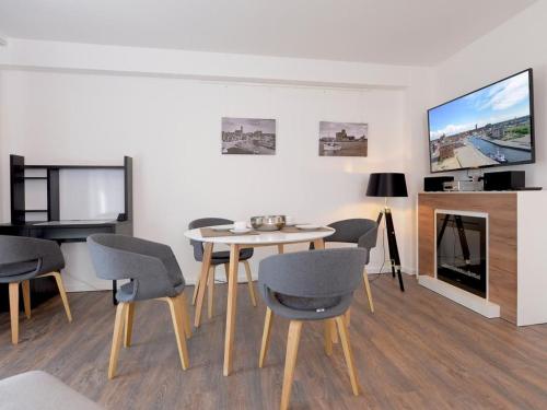 a living room with a table and chairs and a tv at Ohlerich Speicher App_ 36 in Wismar
