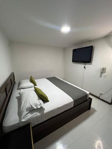 a bedroom with a bed and a flat screen tv at hotel torre 52 in Bogotá