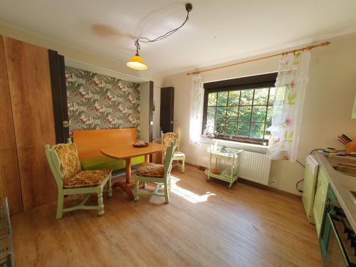 a dining room with a table and chairs and a window at Ferienwohnung Am Traumgarten, 35646 in Uplengen