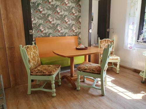 a dining room table with two chairs and a wooden table at Ferienwohnung Am Traumgarten, 35646 in Uplengen