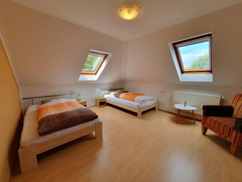 a bedroom with two beds and a couch and two windows at Ferienobjekte Claus, 35633 in Uplengen