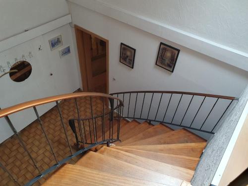 a spiral staircase in a house with a wooden floor at Ferienobjekte Claus, 35633 in Uplengen