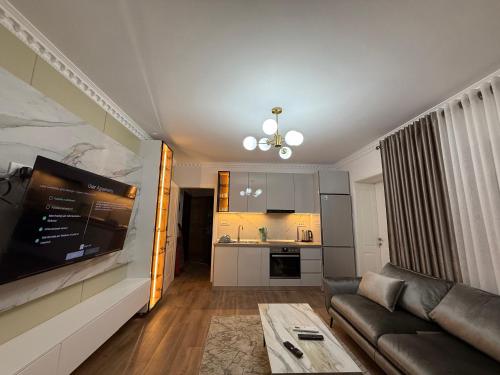 a living room with a couch and a kitchen at Royal Stay Apartment 1 min walk of city centre in Elbasan
