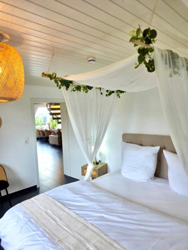 a bedroom with a white bed with a canopy at Residenz Cheval - BOHO - Ravensburg - Bodensee in Ravensburg
