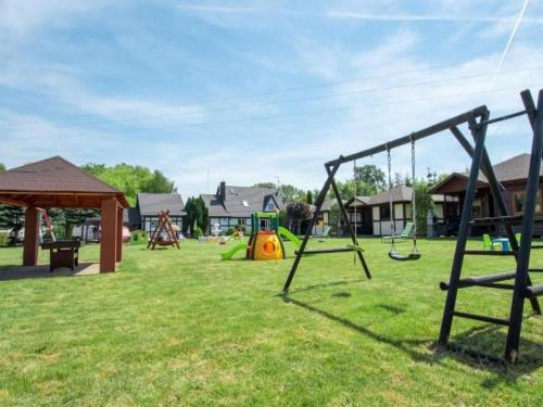 a park with swings and a playground at Holiday House cko near Baltic Beach in Łacko