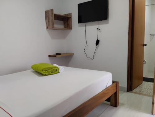 a bedroom with a bed and a television on the wall at HOTEL LA SELVA JARDIN in Jardin