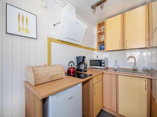 a small kitchen with wooden cabinets and a counter top at Holiday House cko near Baltic Beach in Łacko