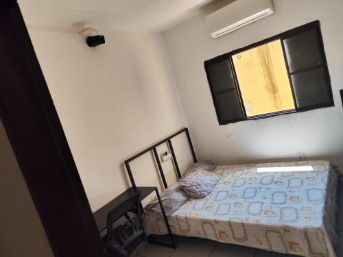 a small bedroom with a bed and a window at Pousada 4 Estações in Botucatu