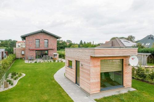 ein kleines Haus mit Holzverkleidung im Hof in der Unterkunft Ferienhaus Wiesenblick in Ahlbeck