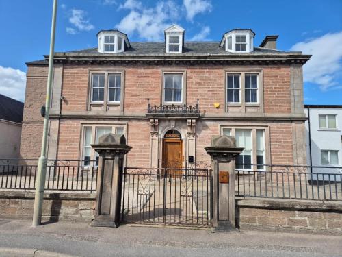 an old brick house with a gate in front of it at Bank House in Inverness