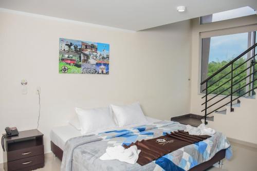 a bedroom with a bed and a window and a staircase at Hotel Villa Colonia in Marinilla