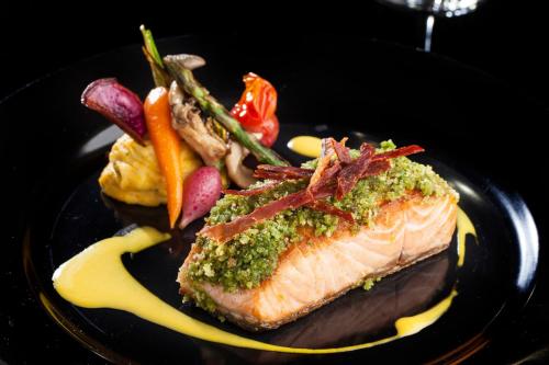 a black plate of food with meat and vegetables at InterContinental São Paulo by IHG in Sao Paulo