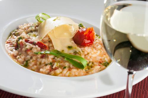 a bowl of food on a plate next to a wine glass at InterContinental São Paulo by IHG in Sao Paulo