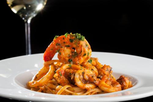 a plate of shrimp pasta with a glass of wine at InterContinental São Paulo by IHG in Sao Paulo
