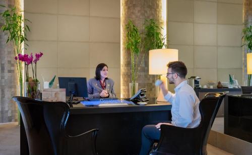 a man and a woman sitting at a desk in an office at InterContinental São Paulo by IHG in Sao Paulo