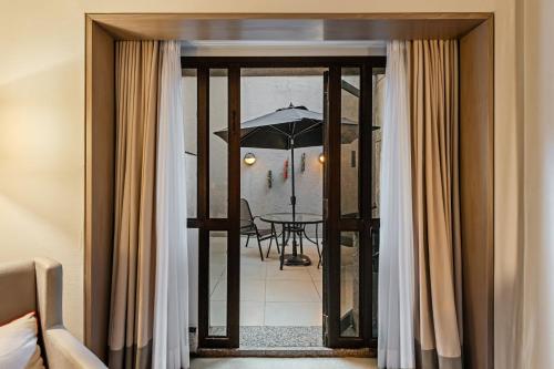 a room with a balcony with a table and an umbrella at InterContinental São Paulo by IHG in Sao Paulo